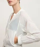 Campera deportiva estilo rompevientos cropped, color blanco, con capucha y cierre frontal.