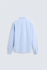 Camisa celeste a rayas verticales blancas, de corte recto, con cuello italiano abierto, mangas largas con puños abotonados y cierre frontal con botones.