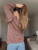 Sweater de punto calado color crema, con mangas largas y volados en los hombros. Tiene corte holgado y etiqueta de cuero con logo en la parte inferior.