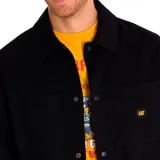 Chaqueta negra de twill de algodón con cierre frontal a presión, bolsillos superiores en el pecho y en la parte inferior, puños elásticos, forro con logo de Caterpillar y bolsillo interior en el pecho.