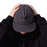 Gorra de visera plana color gris con logo estampado en negro y bordado de la marca en rojo.