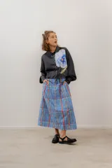 Camisa crop azul con estampado de motivos abstractos en blanco y rosa, cuello clásico y lazo en el escote.