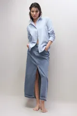 Falda larga de jean azul con abertura frontal y ruedo desflecado.