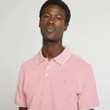 Remera polo de piqué color salmón con cuello y mangas con ribete blanco.