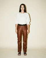 Pantalón de cuero vacuno color marrón, con forrería interna de satén y presillas fruncidas.