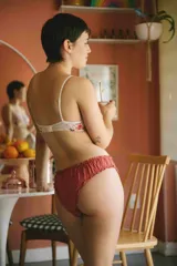 Pantie de viscosa negra con estampado de flores rosas y volados en cintura y piernas.
