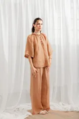 Pantalón de lino blanco, de corte ancho y tiro alto, con cintura elastizada y cordón ajustable.