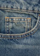 Jeans de tiro alto color azul denim, corte mom fit, con cinco bolsillos, trabillas y cierre frontal con cremallera y botón.