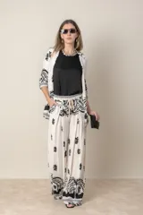 Pantalón palazzo de lino y viscosa color crudo con estampado de hojas en marrón chocolate.
