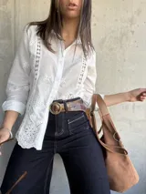 Camisa blanca de manga larga con bordado inglés y cierre frontal con botones.