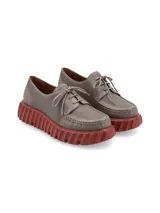 Zapato acordonado color gris con suela de goma color ladrillo.