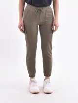 Pantalón deportivo tipo cargo de color verde militar, con cintura elástica ajustable con cordón y puños ajustados en los tobillos. Presenta bolsillos laterales tipo parche en la parte superior y bolsillos cargo a la altura de los muslos.