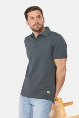 Chomba azul con textura de líneas horizontales en relieve, cuello clásico y tapeta con dos botones.