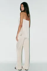 Pantalón de vestir color crema de tela satinada, corte palazzo y tiro alto.