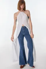 Conjunto de top halter con abertura en el abdomen y falda cruzada con ruedo desflecado, color fucsia.