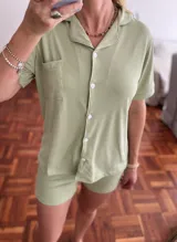 Conjunto de pijama corto color verde claro, de tela acanalada. Incluye camisa de mangas cortas con cuello y botones, y short con cintura elástica.