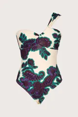 Traje de baño entero con estampado floral en tonos morado, verde y blanco. Diseño asimétrico con un solo hombro y corte bandeau.