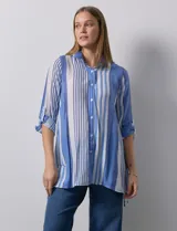 Camisa larga de rayón marca Robert Louis, con estampado a rayas verticales en tonos coral y blanco. Tiene cuello con solapa, abertura central con botones, mangas largas regulables con presilla y botón, y tajos laterales.