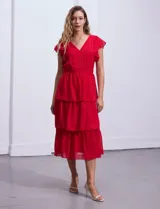 Vestido blanco de gasa con capas de la marca Julia Jordan. Tiene escote en V, mangas cortas con volados, corte en la cintura, abertura central en la espalda con cierre invisible y forro interno a tono.