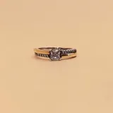 Anillo de plata 925 y oro con una circonia central cuadrada y circonias pequeñas en la banda. El ancho inferior de la alianza es de 1.2mm.