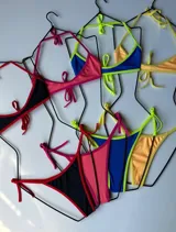 Bikini de dos piezas color amarillo liso, con corpiño triangular y bombacha de corte bajo con tiras finas ajustables en los laterales.