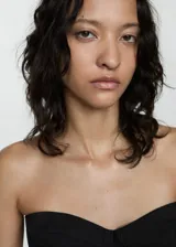 Top negro sin mangas con diseño ajustado y escote estructurado.