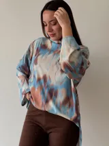 Sweater de cuello alto con estampado abstracto en tonos celeste, marrón y blanco.
