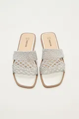 Sandalias bajas color blanco con tiras anchas de tejido trenzado.
