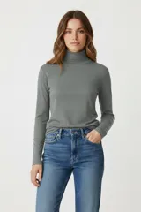 Polera gris de algodón y elastano, corte ajustado y cuello alto.