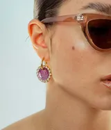 Par de aros colgantes con dije circular de resina con glitter multicolor y borde de strass. El arito es de acero quirúrgico dorado.