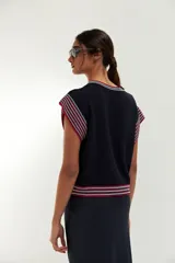 Top tejido de punto color azul marino, con cuello redondo y mangas cortas con rayas horizontales en rojo, blanco y azul.