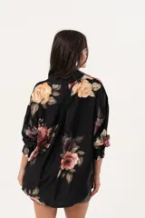 Camisa oversize negra con estampado floral, abotonada y con cuello camisero.