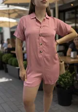 Mono corto rosado, con cuello camisero, manga corta y cierre frontal de botones marrones.