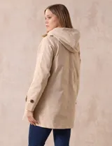 Gabardina impermeable color beige, marca Weatherproof, con abertura central con botones, bolsillos delanteros y capucha desmontable.