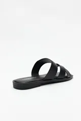 Sandalia plana color marrón con tiras anchas cruzadas, punta cuadrada y base levemente acolchonada.