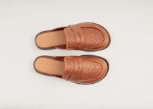 Mocasín mule de cuero negro con capellada tejida.