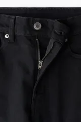 Pantalón de jean negro de corte skinny, tiro alto y cinco bolsillos.