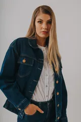 Campera bomber de denim azul oscuro con cuello clásico, cierre frontal con botones metálicos y dos bolsillos con solapa en el pecho.