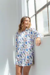 Camisa blanca con estampado de flores, perros, sillas y jarrones.
