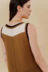 Vestido midi color crema, tejido de punto con bloques de diferentes texturas, escote redondo y sisas con terminación ondulada.