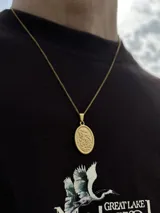 Cadena dorada con dije ovalado de San Miguel Arcángel.