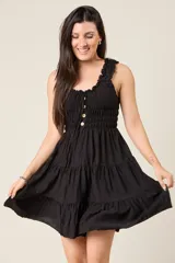 Vestido corto rojo con escote fruncido, tirantes anchos con volantes y cuerpo de nido de abeja. Falda con diseño escalonado.