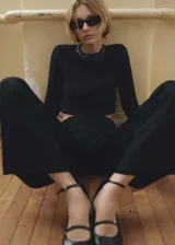 Pantalón de vestir negro de corte recto, con tiro medio, trabillas para cinturón, pinzas frontales y bolsillos laterales.