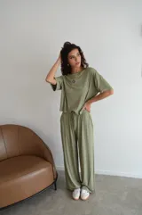 Conjunto deportivo verde oliva compuesto por una remera de mangas cortas con logo en el pecho y un pantalón palazzo con cordón ajustable en la cintura.