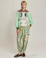 Pantalón cargo de viscosa con estampado de sombreros de vaquero, cactus y vaqueros a caballo. Tiene dos bolsillos laterales y dos bolsillos grandes en la rodilla. Cintura elástica.