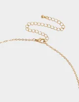 Cadena dorada con dije de corazón con piedras de zirconia rosas y blancas.