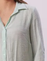 Camisa larga de rayón marca Robert Louis, color beige. Tiene cuello con solapa, abertura central con botones y mangas regulables con presilla y botón. Los laterales tienen tajo.