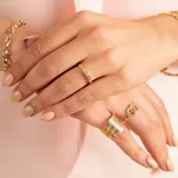 Anillo de oro amarillo 18k con circonias engarzadas en la mitad superior.