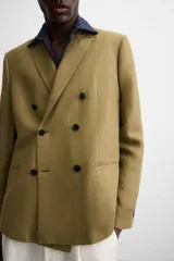 Blazer color marrón claro, de corte recto y doble botonadura. Confeccionado en tejido de lyocell y lino.