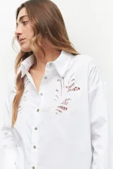 Camisa de manga larga blanca, confeccionada en algodón con bordados en el torso y terminaciones del cuello y mangas.